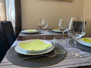 einen Esstisch mit Tellern und Weingläsern in der Unterkunft Casa d'artista in Val di Chiana in Sinalunga