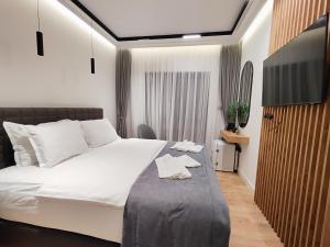 a bedroom with a large white bed with a tv at AMD Premium rooms Budva in Budva