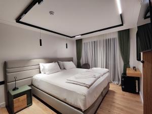 a bedroom with a large white bed in a room at AMD Premium rooms Budva in Budva