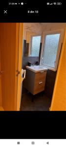 ein kleines Bad mit einem Waschbecken und einem Fenster in der Unterkunft Bungalow WILLERBY in Maasmechelen