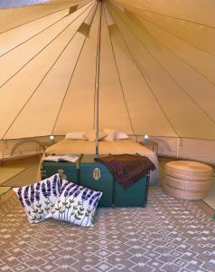 een kamer met een tent met een bed en kussens bij Lavender Glamping in Elmas