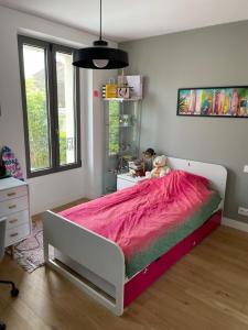 1 dormitorio con 1 cama grande con manta rosa en Maison de famille à Chatou - 20 mins RER Paris - Jusqu'à 7 personnes en Chatou