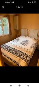 ein großes Bett in einem Zimmer mit Fenster in der Unterkunft Bungalow WILLERBY in Maasmechelen