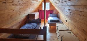 a room with two beds in a wooden cabin at Haus an der Pferdekoppel am Blankenburger See in Blankenburg Oberuckersee