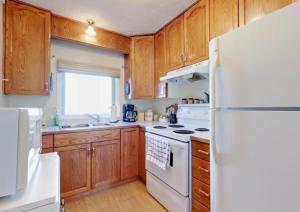 cocina con nevera blanca y armarios de madera en Home Away from Home - Guest Suite 1 en Red Deer