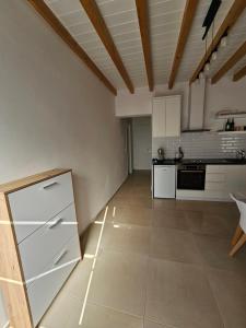 een keuken met witte kasten en een tegelvloer bij Vacation Domgjon in Rrëshen