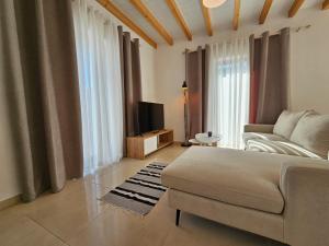 een woonkamer met een bank en een tv bij Vacation Domgjon in Rrëshen