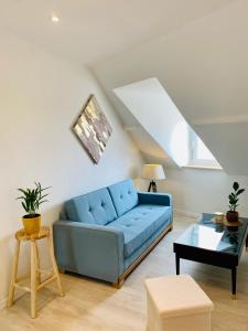 - un salon avec un canapé bleu et une table dans l'établissement Lou & Moi Appartement à 50m de la plage, à Cayeux-sur-Mer