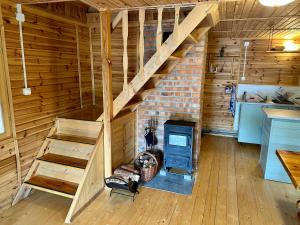 Cabaña de madera con escalera y chimenea en Leśniczówka, en Rządza