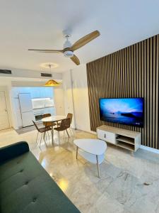 a living room with a couch and a tv and a table at Apartamento Vacacional Sol y Mar in Manilva