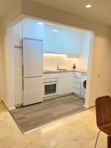 a kitchen with a white refrigerator and a dishwasher at Apartamento Vacacional Sol y Mar in Manilva
