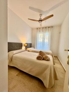 a bedroom with two beds and a ceiling fan at Apartamento Vacacional Sol y Mar in Manilva +9 photos
