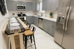 a kitchen with a table with chairs and a refrigerator at Brickell + Wynwood Wonderland: Spacious 6BR Home in Miami