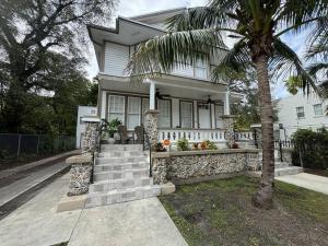 a white house with a palm tree in front of it at Brickell + Wynwood Wonderland: Spacious 6BR Home in Miami