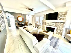 a living room with a white couch and a fireplace at Brickell + Wynwood Wonderland: Spacious 6BR Home in Miami