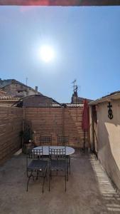 a patio with a table and chairs and a brick wall at Appartement intra-muros in Aigues-Mortes
