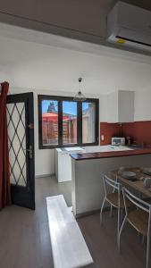 a kitchen with a counter and a table with chairs at Appartement intra-muros in Aigues-Mortes