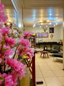 una sala de estar con flores rosas en el primer plano en Pousada Tianguá - Top Demais, en Tianguá