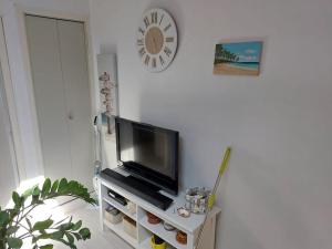 een woonkamer met een flatscreen-tv op een standaard bij Location Maison de vacances aux Sables d'Olonne in Talmont