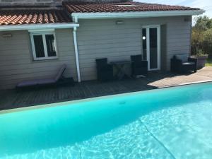 a house with a swimming pool in front of a house at La Chartreuse des Vignes in Ludon-Médoc