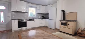 a kitchen with white cabinets and a stove top oven at Fortuna Livno Holiday House in Livno