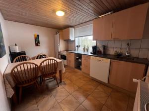 a kitchen with a table and some chairs and a table and a kitchen at The Annex @ Bloksgaard in Hirtshals