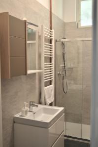 a white bathroom with a sink and a shower at Apartment Trdinova in Ljubljana