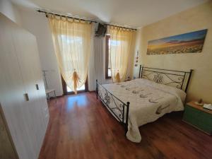 - une chambre avec un lit et une grande fenêtre dans l'établissement Goccia in Valdorcia Smart Home, à San Quirico dʼOrcia