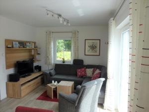 TV a/nebo společenská místnost v ubytování Gemütliches Ferienhaus mit Sauna am Kurpark gelegen und nur 350 Meter vom Strand entfernt