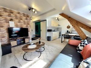 a living room with a large television and a table at Cocon sous le toit in Carignan