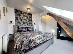 a bedroom with a large bed with a patterned bedspread at Cocon sous le toit in Carignan