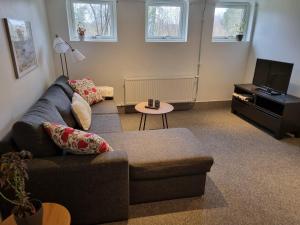 sala de estar con sofá y TV en Apartment Enebacken close Göteborg, en Mölnlycke