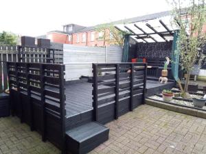 a garden with a black and white fence at Beautiful 2-Bed House in Bolton with free parking in Bolton