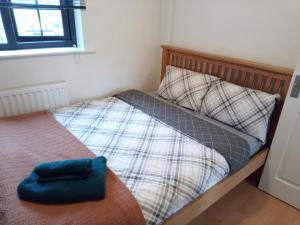 a bed with a blue pillow on top of it at Beautiful 2-Bed House in Bolton with free parking in Bolton