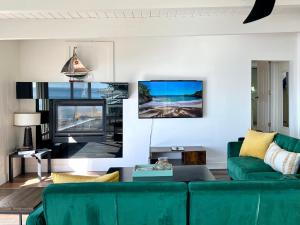 een woonkamer met een groene bank en een tv bij Panoramic Ocean View Cottage Unit #4 in San Clemente