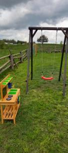 a playground with a swing and a table and a bench at Między Jeziorami in Ogonki