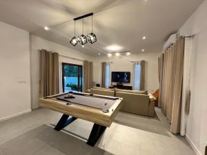 a living room with a pool table in it at บ้านพูลวิลล่าอุดรธานี by บ้านแสนรัก in Udon Thani