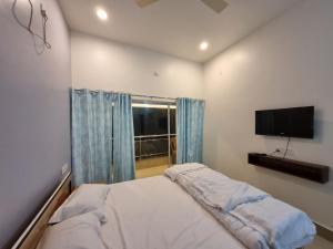 a bedroom with a bed and a flat screen tv at Bonobitaan Hotel & Restaurant in Bolpur