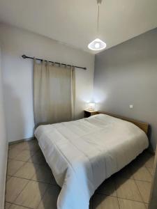 sypialnia z białym łóżkiem i oknem w obiekcie Cozy Nest w mieście Neo Karlowasi