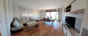 ein Wohnzimmer mit einem Sofa und einem Tisch in der Unterkunft Apartamento Casa A Braña in O Grove