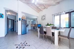 een keuken en eetkamer met een tafel en stoelen bij Ferienhaus mit Privatpool für 7 Personen ca 100 qm in Castiadas, Sardinien Sarrabus Gerrei in Olìa Speciosa