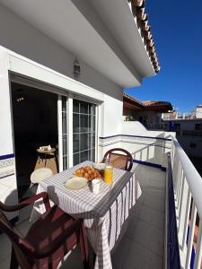 a table with a plate of food on a balcony at Apartamento Dúplex Cala de Mijas in La Cala de Mijas