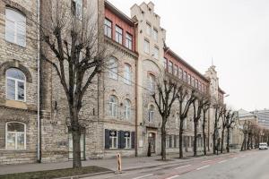 une rangée d'arbres devant un bâtiment en briques dans l'établissement City Center Loft2 Apartment, à Tallinn