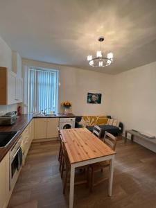 a kitchen with a wooden table and a dining room at Perfect Ardrossan 1-bed flat. 5 min to north beach. in Ardrossan