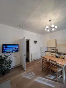 a living room with a table and a kitchen at Perfect Ardrossan 1-bed flat. 5 min to north beach. in Ardrossan