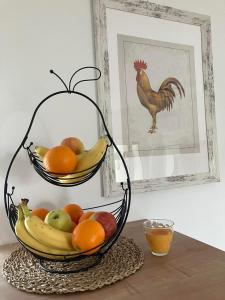 a basket of fruit on a table with a picture of a chicken at Apartman Vita in Bjelovar +2 photos