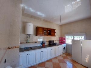 una cucina con armadietti bianchi e frigorifero bianco di Vintage Palace a Ksar es-Seghir