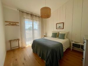 a bedroom with a bed and a large window at Villa du Canal - Ponton pour bateau in Cazaux