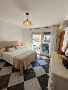 a bedroom with a bed and a checkered floor at Apartamento Dúplex Cala de Mijas in La Cala de Mijas