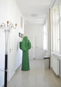 a green cactus statue in a hallway with white walls at Apartment Trdinova in Ljubljana